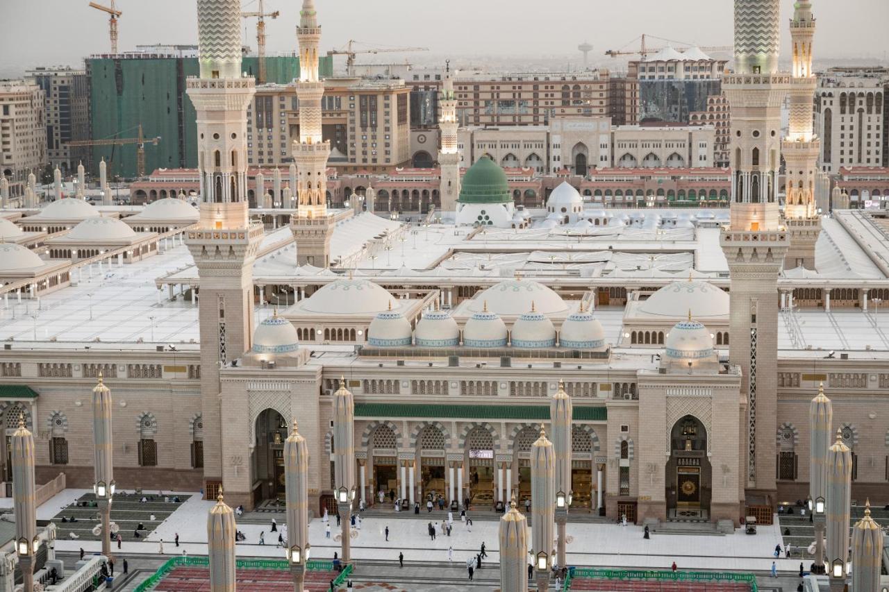 Sofitel Shahd Al Madinah Hotel Medina Buitenkant foto The photo shows an aerial view of a mosque complex, with prominent architectural features such as tall minarets and a large dome. The structure is notable for its intricate design and is likely surrounded by an open courtyard where people are gathere